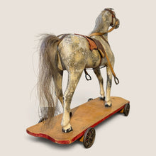 Load image into Gallery viewer, Ziebarth's Antiques vintage wooden pull toy horse with weathered finish, leather saddle, and metal wheels on platform