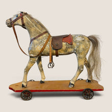 Load image into Gallery viewer, Ziebarth's Antiques vintage wooden pull toy horse with weathered finish, leather saddle, and metal wheels.