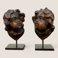 Load image into Gallery viewer, Ziebarth's Antiques pair of hand-carved wooden cherub head sculptures on minimalist black metal stands.