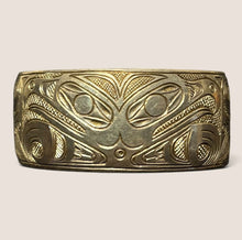 Load image into Gallery viewer, Ziebarth's Antiques gold-tone metal cuff bracelet featuring intricate, deeply etched Northwest Coast formline art motifs.