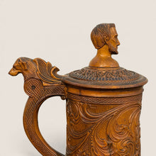 Load image into Gallery viewer, Ziebarth's Antiques hand-carved wooden beer stein with intricate floral relief, dog-head handle, and bust finial lid.